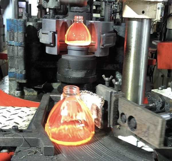 triangle shaped glass bottle with embossed logo on production line