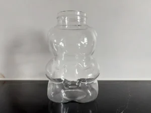 Clear bear-shaped borosilicate glass bottle body with a threaded opening